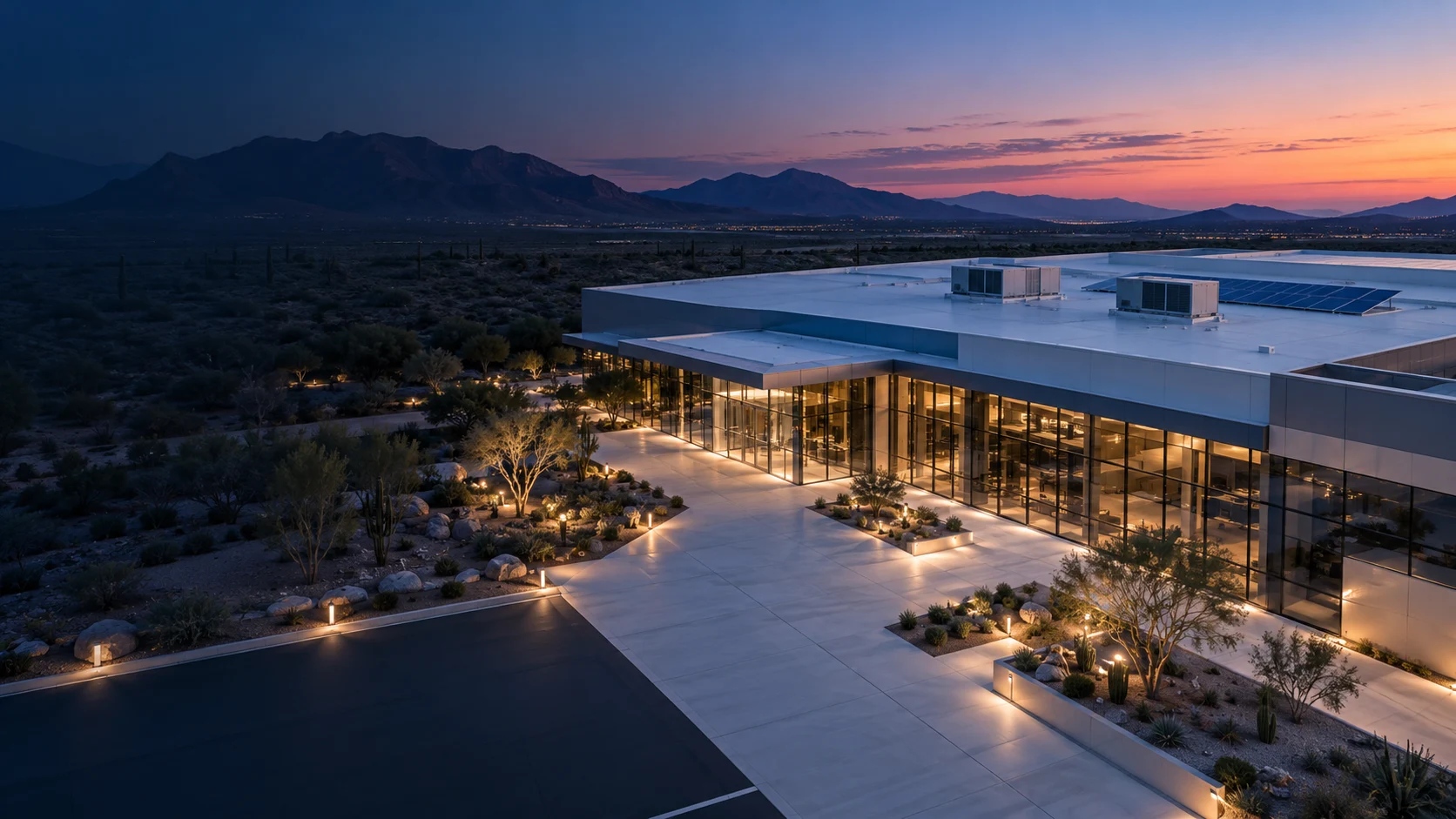 modern Arizona building at blue hour, with rooftop equipment and landscaped grounds
